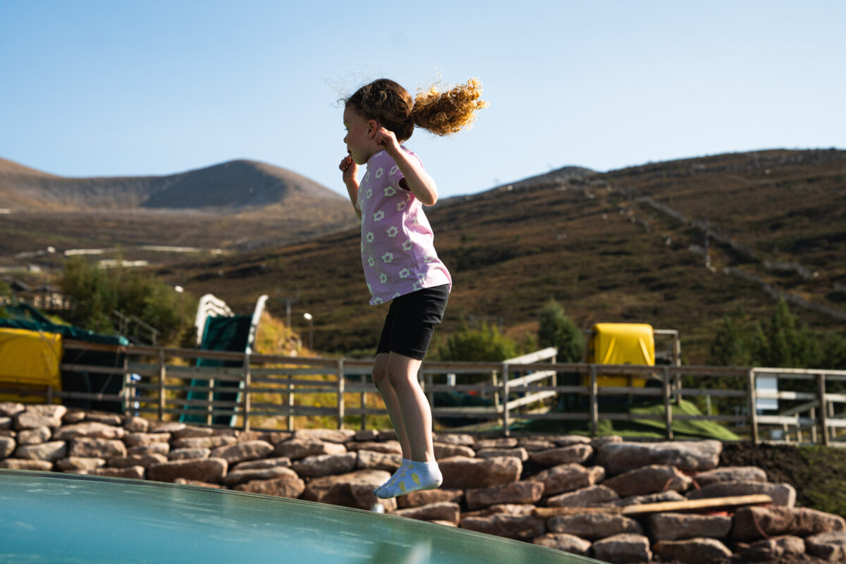 Girl jumping on trampoline type play area